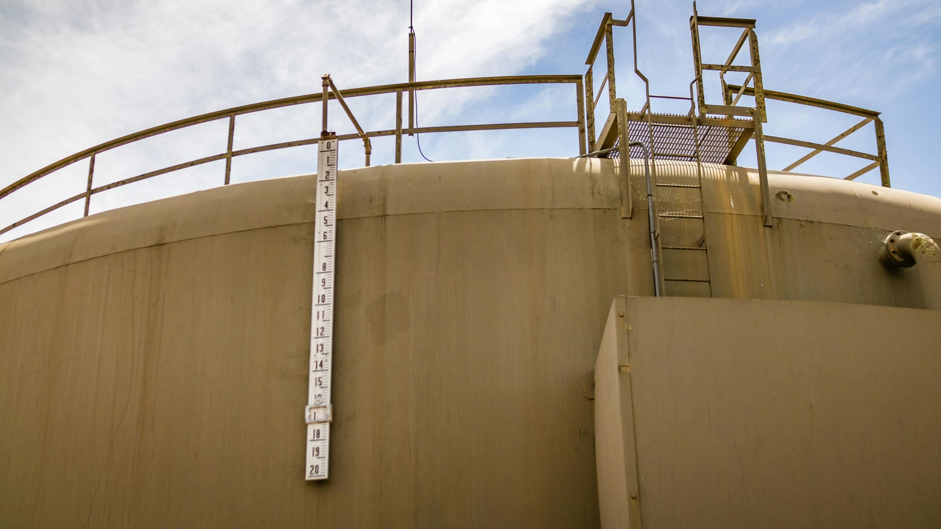 Top of a petroleum storage tank showing the automatic tank gauging ladder and access platform.